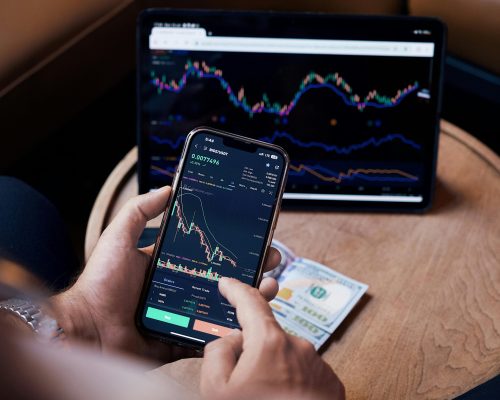 Man Looking at the Stock Charts on the Phone and Tablet